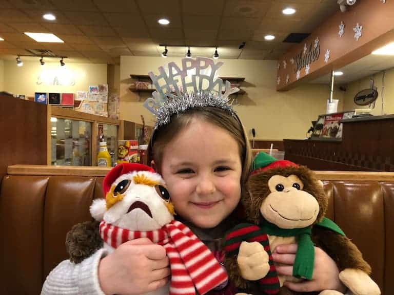 little girl wearing a happy birthday crown and smiling at the camera